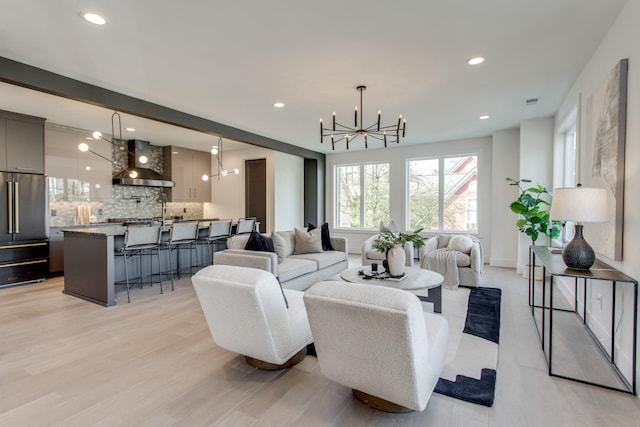 living room featuring a notable chandelier and light hardwood / wood-style flooring