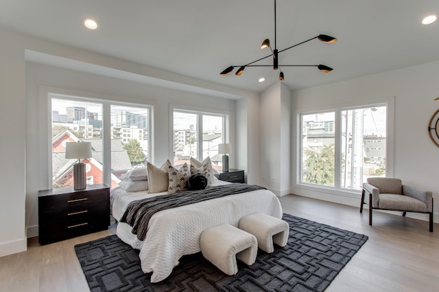 bedroom featuring a notable chandelier and light wood-type flooring