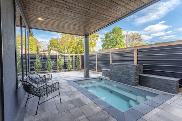 view of pool with a patio and an in ground hot tub