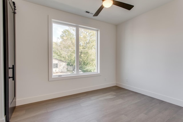 spare room with ceiling fan and light wood-type flooring