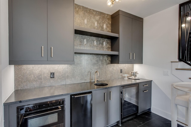 kitchen with gray cabinets, black oven, tasteful backsplash, sink, and beverage cooler