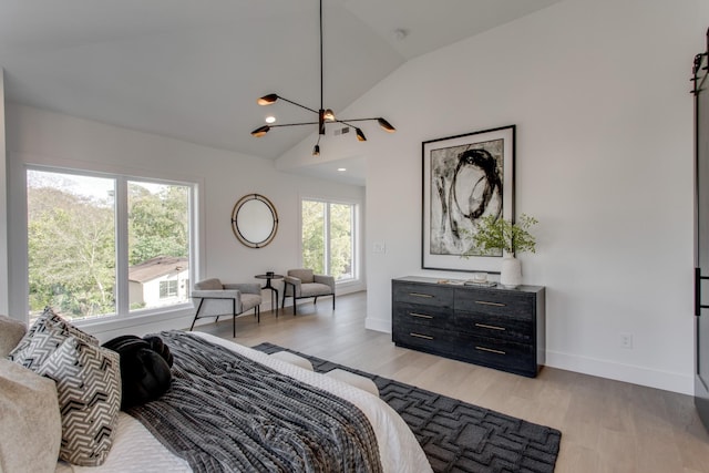 bedroom featuring multiple windows, vaulted ceiling, and light hardwood / wood-style flooring