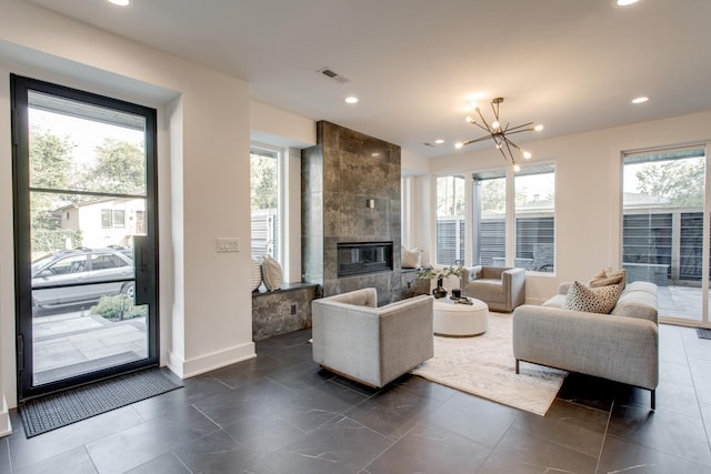 living room featuring plenty of natural light, a fireplace, and a chandelier