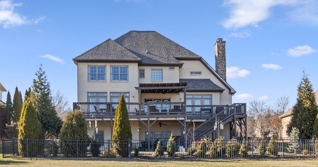 rear view of property featuring ceiling fan and a deck