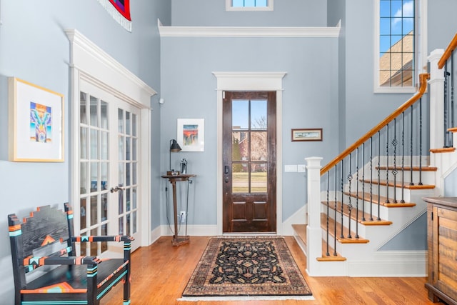 entrance foyer with a high ceiling, wood-type flooring, and french doors