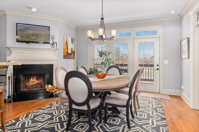 dining area featuring an inviting chandelier, crown molding, and light wood-type flooring