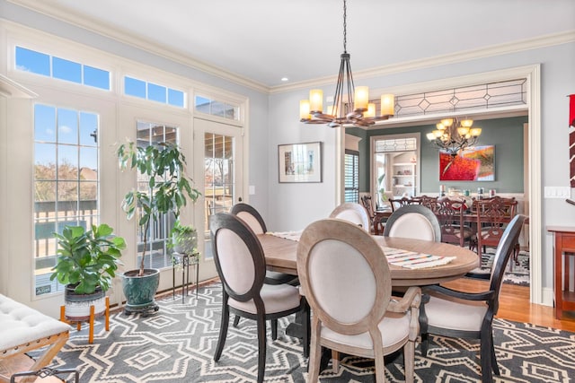 dining room with crown molding, hardwood / wood-style floors, and a notable chandelier