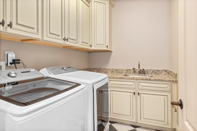 laundry room featuring sink, washing machine and dryer, and cabinets