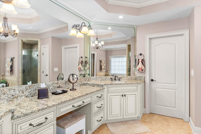 bathroom featuring ornamental molding, a raised ceiling, and a chandelier