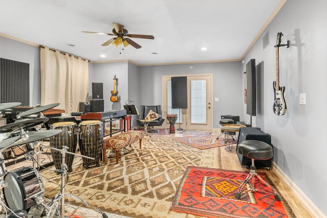 living room featuring ceiling fan, ornamental molding, and wood-type flooring