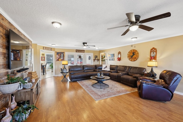 living room featuring ornamental molding, a textured ceiling, and light hardwood / wood-style floors