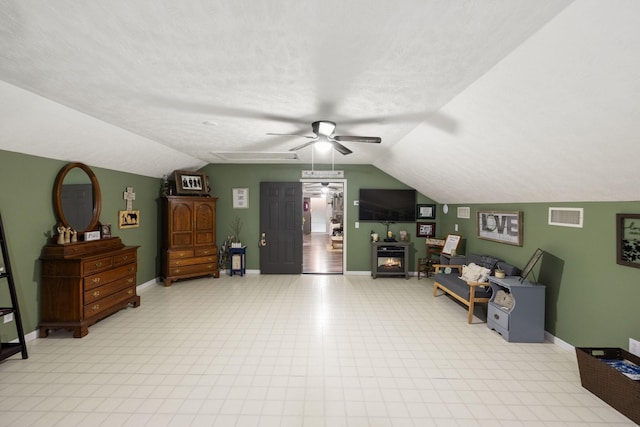 living room featuring ceiling fan, lofted ceiling, and a textured ceiling