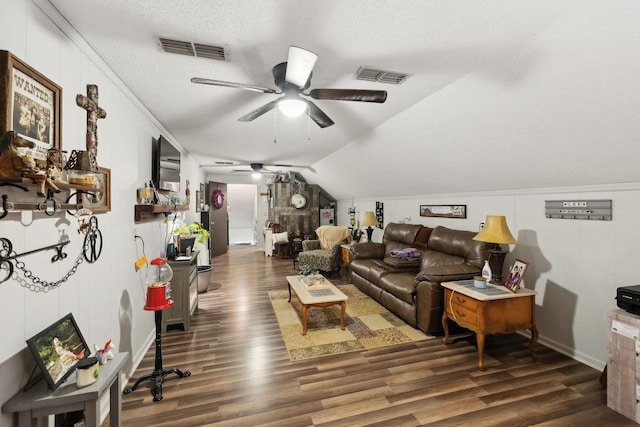 living room featuring lofted ceiling, ceiling fan, dark wood-type flooring, and a textured ceiling