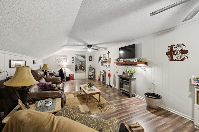 living room featuring lofted ceiling, dark wood-type flooring, a textured ceiling, and ceiling fan