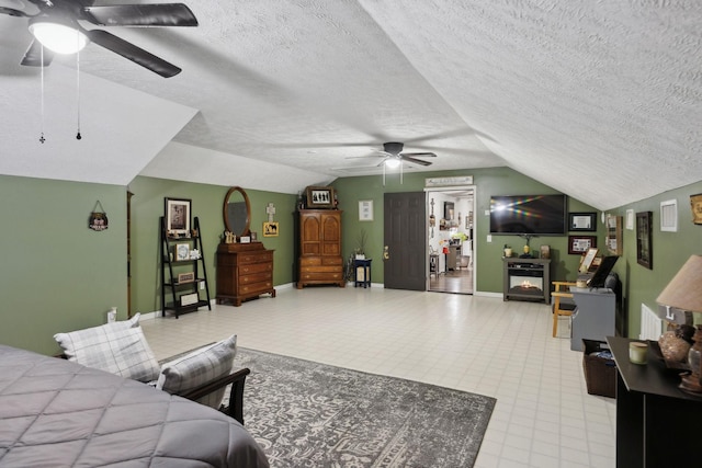 bedroom with a fireplace, a textured ceiling, vaulted ceiling, and ceiling fan