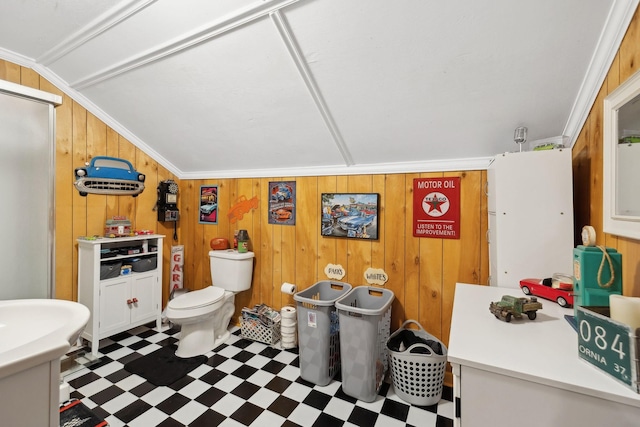 bathroom with vaulted ceiling, ornamental molding, and wood walls