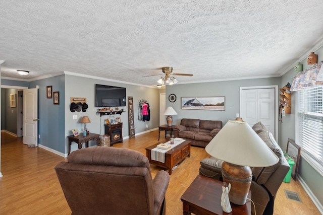 living room with ornamental molding, a textured ceiling, ceiling fan, and light hardwood / wood-style flooring