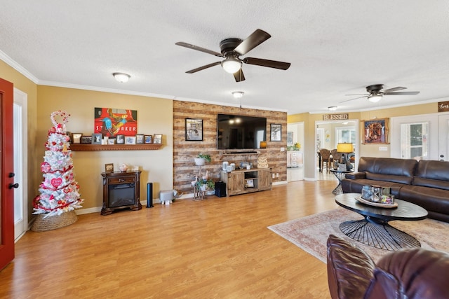 living room with hardwood / wood-style flooring, ornamental molding, a fireplace, and a textured ceiling