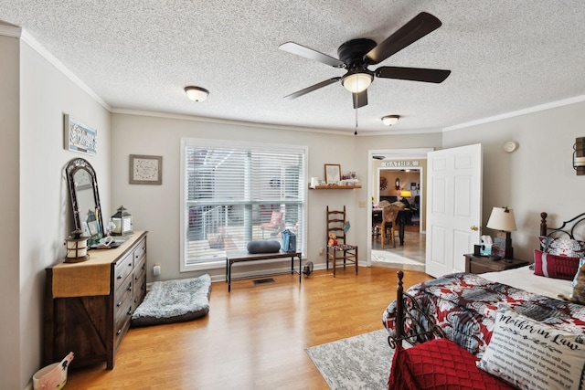 bedroom with crown molding, a textured ceiling, ceiling fan, and light wood-type flooring