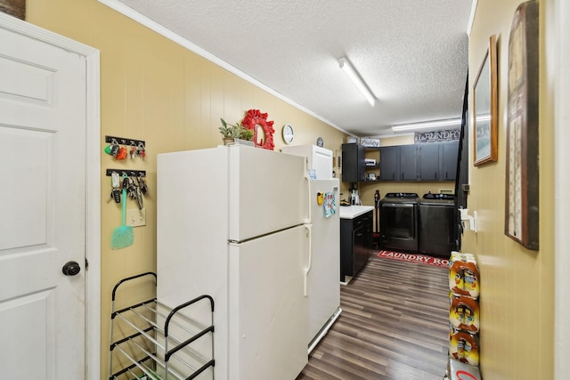 kitchen with dark wood-type flooring, washing machine and dryer, ornamental molding, a textured ceiling, and white fridge