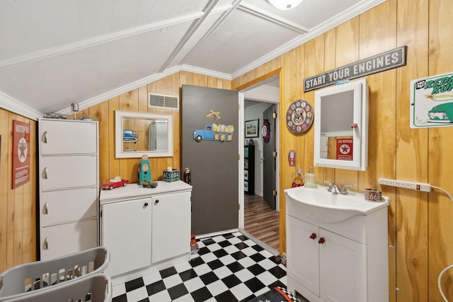 bathroom featuring ornamental molding, lofted ceiling, vanity, and wood walls