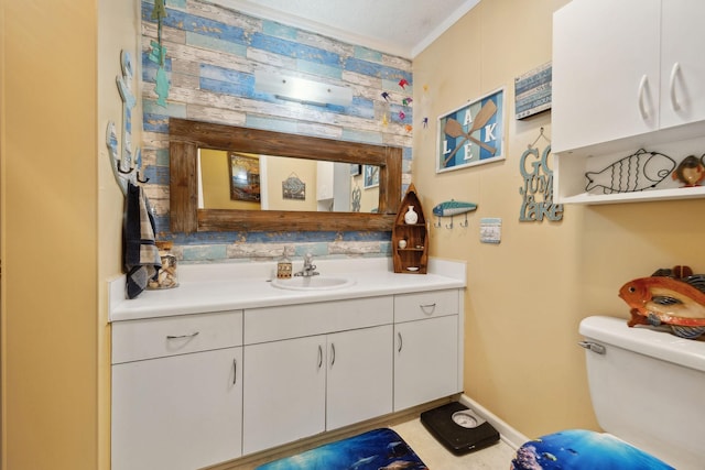 bathroom with vanity, crown molding, and toilet