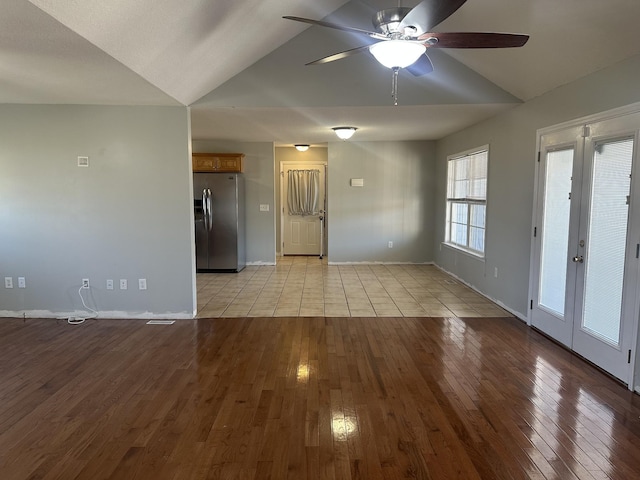 spare room with french doors, ceiling fan, vaulted ceiling, and light wood-type flooring