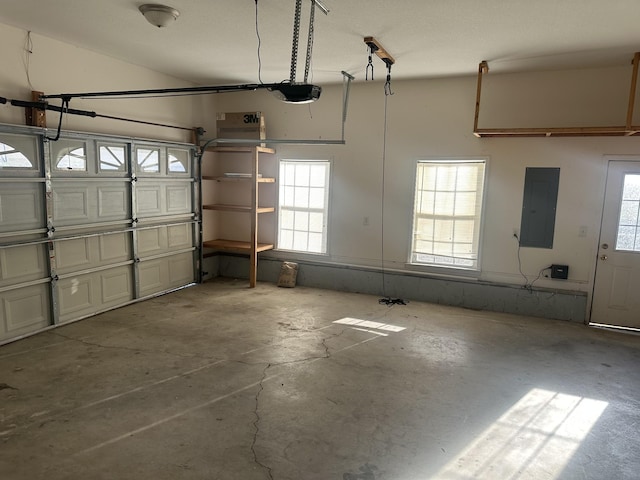 garage with a garage door opener and electric panel