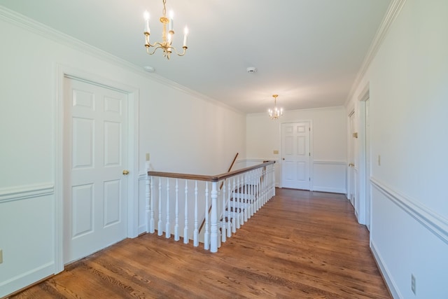 hall featuring hardwood / wood-style flooring, ornamental molding, and a chandelier