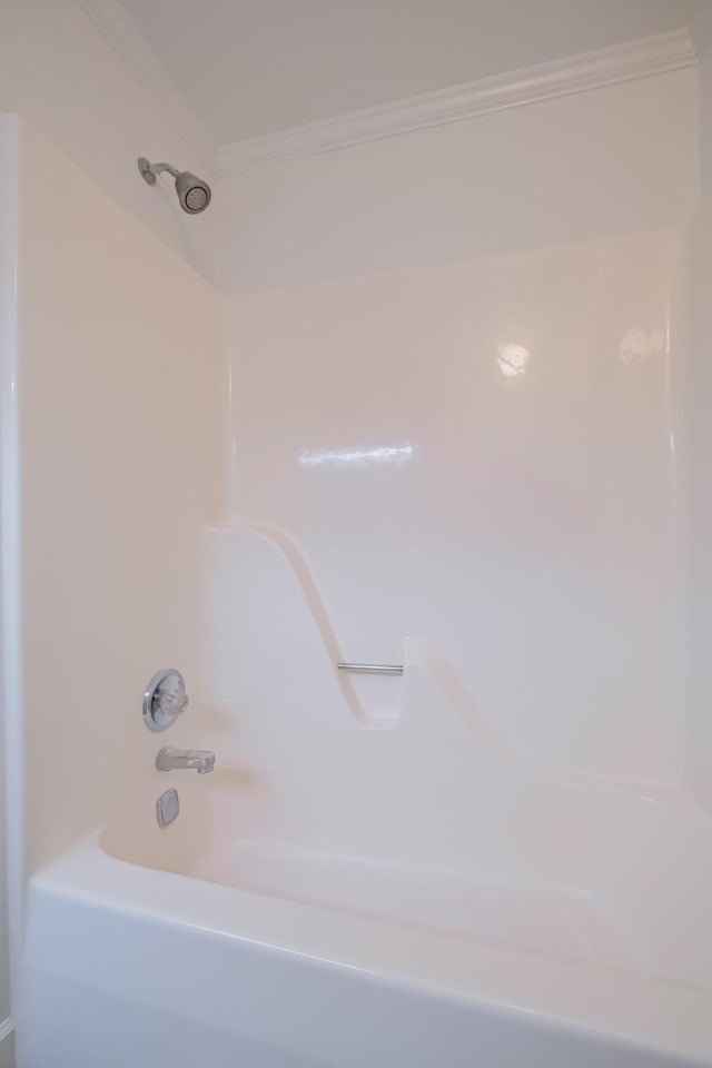 bathroom with ornamental molding and tub / shower combination