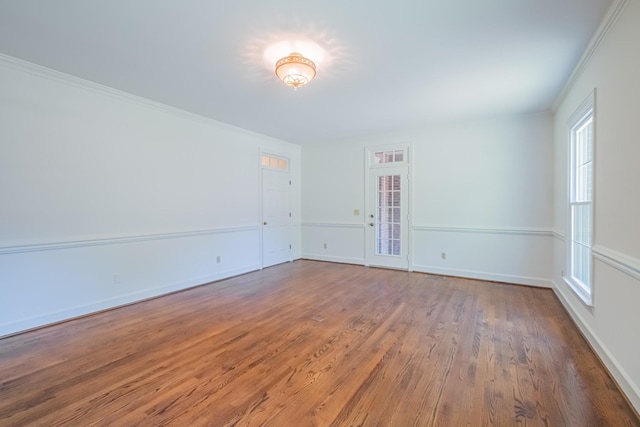 empty room featuring ornamental molding and hardwood / wood-style floors