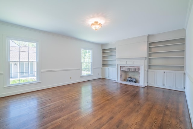 unfurnished living room with a healthy amount of sunlight, dark wood-type flooring, and built in shelves