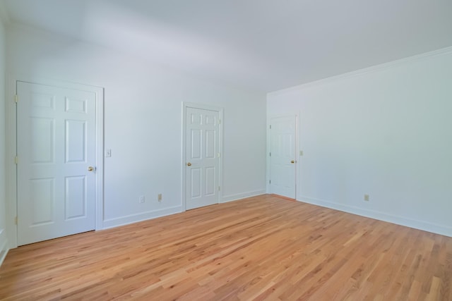 spare room featuring ornamental molding and light hardwood / wood-style floors