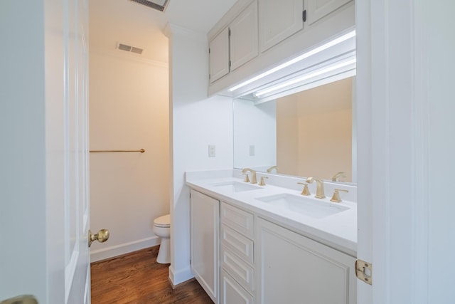 bathroom with ornamental molding, toilet, hardwood / wood-style floors, and vanity