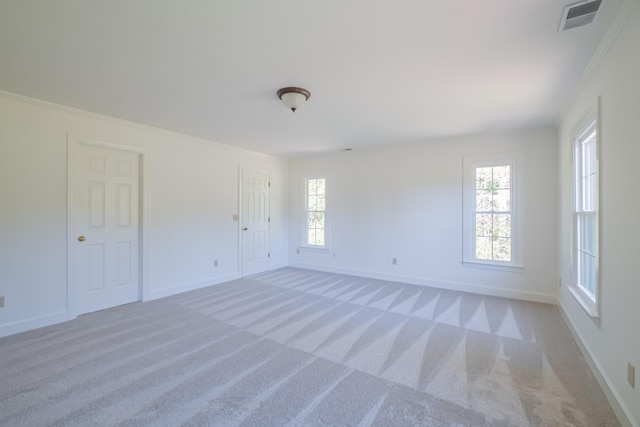 spare room with light colored carpet and ornamental molding