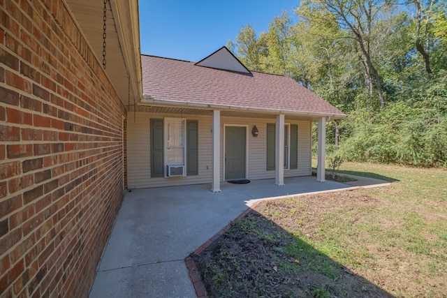 doorway to property with a yard and a patio