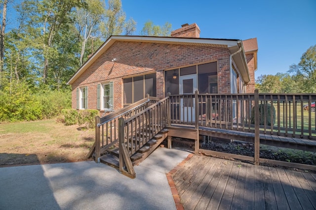 back of house featuring a wooden deck and a yard