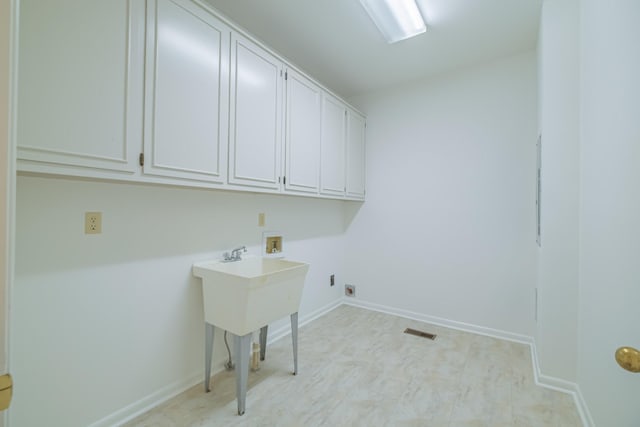 laundry room featuring washer hookup and cabinets