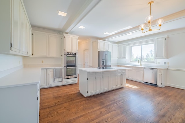 kitchen featuring beam ceiling, a kitchen island, white cabinets, and appliances with stainless steel finishes