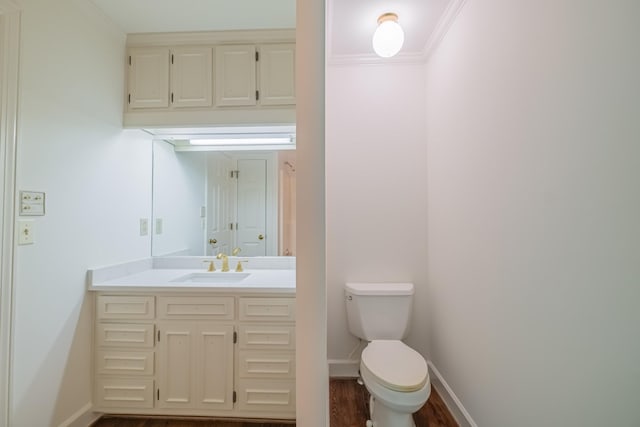 bathroom featuring vanity, crown molding, wood-type flooring, and toilet