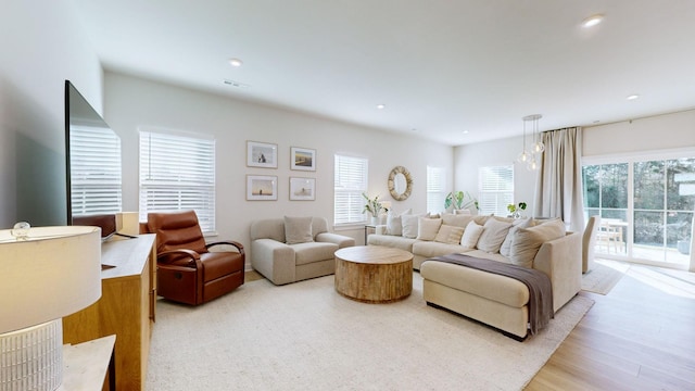 living area with light wood finished floors, visible vents, and recessed lighting