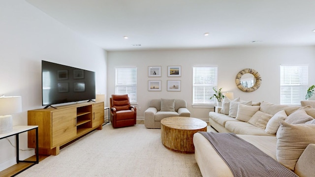 living area with recessed lighting, baseboards, visible vents, and light colored carpet