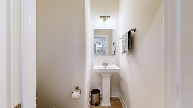 half bathroom with a sink and baseboards