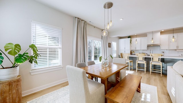 dining area featuring recessed lighting, light wood-style flooring, and baseboards