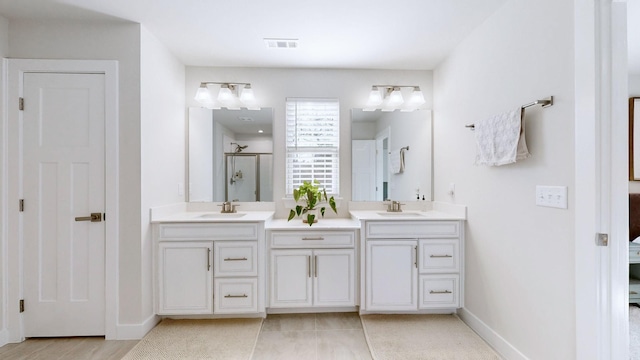 bathroom with double vanity, visible vents, a sink, and ensuite bathroom