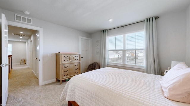 bedroom featuring visible vents, light carpet, and baseboards