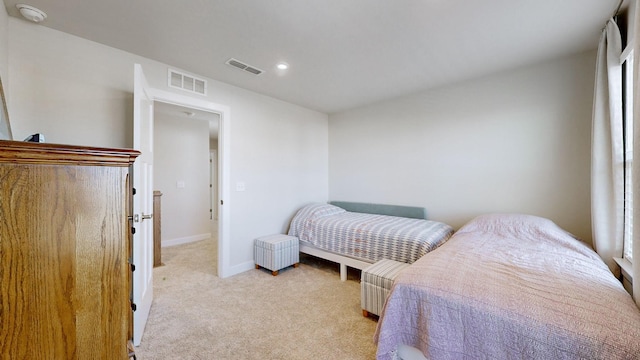 bedroom featuring visible vents, light carpet, and baseboards