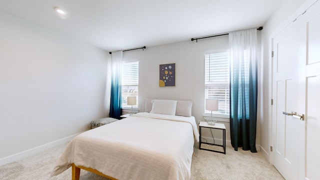 bedroom with carpet, multiple windows, and baseboards