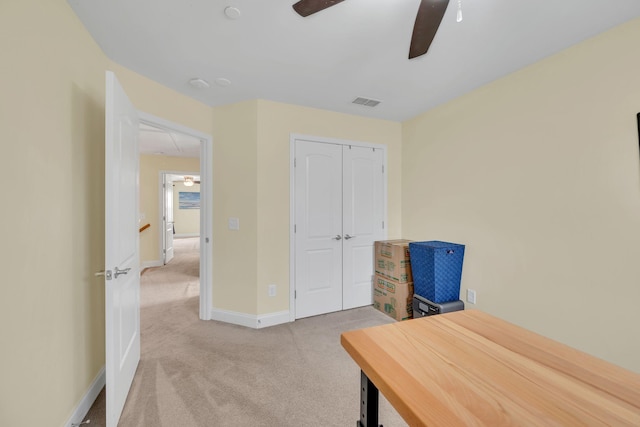 carpeted home office with ceiling fan