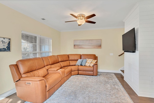 living room featuring dark wood-type flooring, ornamental molding, and ceiling fan